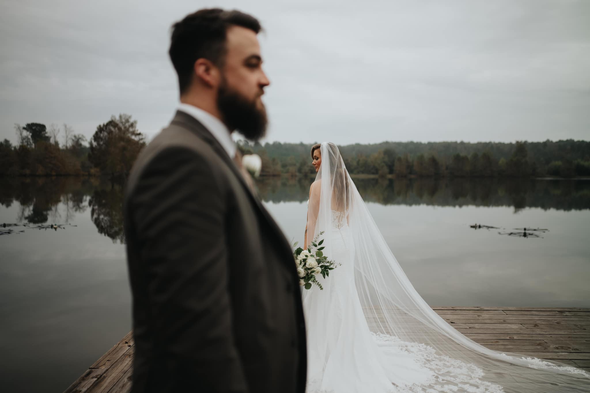 Bride and groom standing on pier in Mississippi.